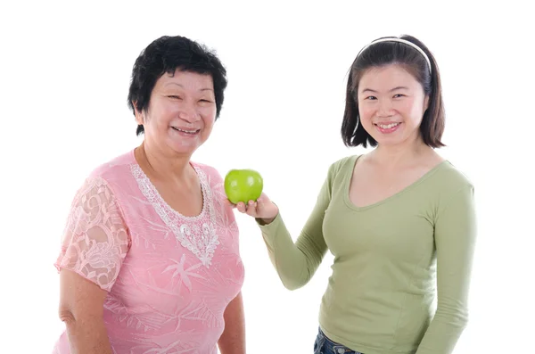 Donna anziana con figlia che ha mela — Foto Stock