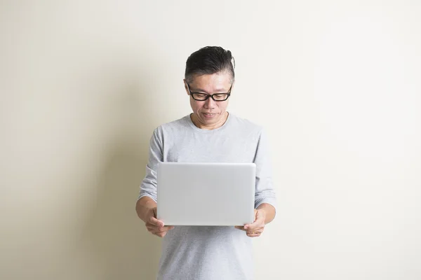 Aziatische senior man met laptop — Stockfoto