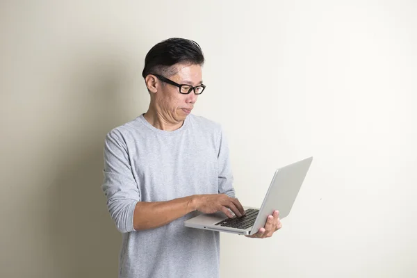 Aziatische senior man met laptop — Stockfoto