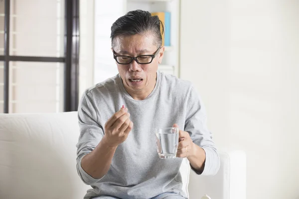 Asiatico senior uomo spilling pills — Foto Stock