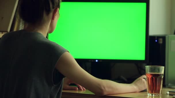 Sopra la spalla colpo di donna digitando su uno schermo verde del computer — Video Stock