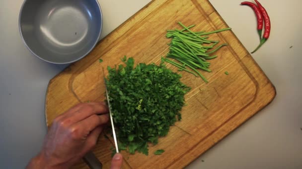 Cook chops parsley on board — Stock Video