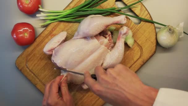Mãos masculinas preparando frango cru inteiro em uma placa de cozinha de madeira — Vídeo de Stock