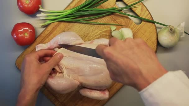 Manliga händer förbereder hela råa kycklingen på en matlagning planka — Stockvideo