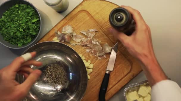 Manliga händer blanda hackad vitlök, gröna, paprika och smör — Stockvideo