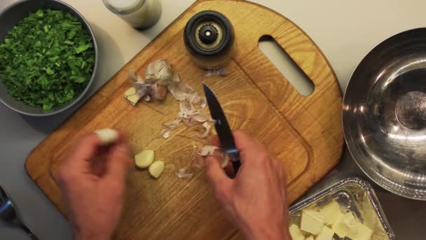Чоловічі руки готують їжу на дерев'яній кухонній дошці зверху — стокове відео