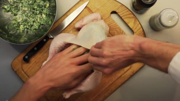 Чоловічі руки готують курку на дерев'яній кухонній дошці зверху — стокове відео
