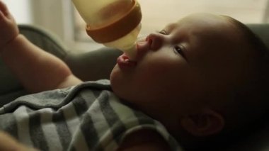 Bebek şişeden süt yiyor.