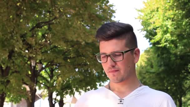 Молодой человек делает селфи в парке — стоковое видео