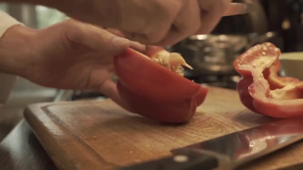 Мужские руки готовят паприку на деревянной кухонной доске — стоковое видео