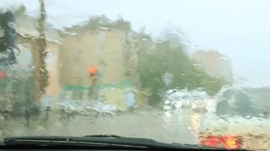 Arabanın ön camında yağmur damlaları var.