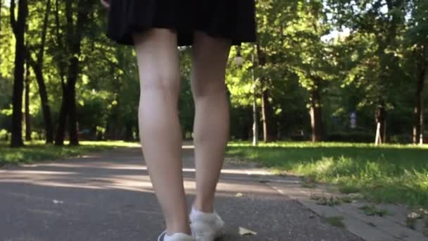 Unga kvinnliga ben promenader i en park — Stockvideo
