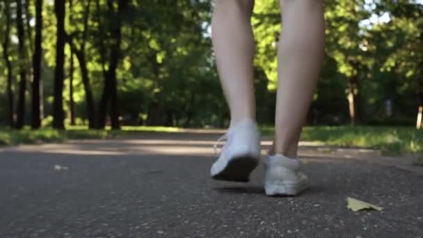 Young female legs walking in a park — Stock Video