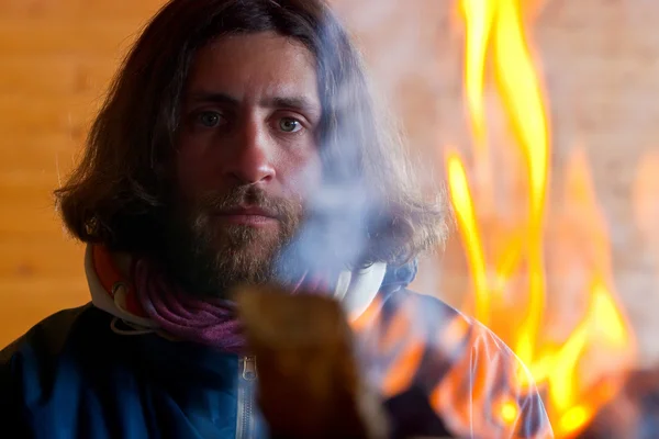 A man with long hair near a fire — Stock Photo, Image