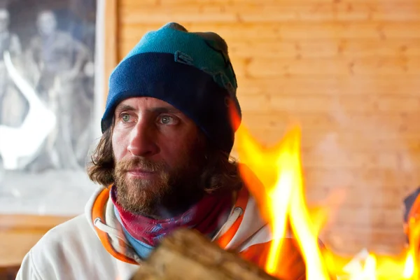 Ein Mann mit langen Haaren bei einem Feuer — Stockfoto