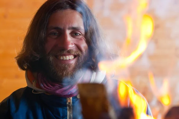 A man with long hair near a fire — Stock Photo, Image