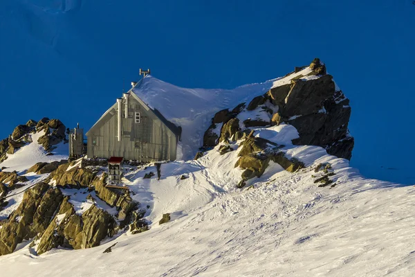 Klein huisje in de bergen — Stockfoto