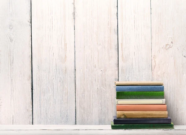 Libros sobre estante de madera, cubierta de espina dorsal fondo de pared de madera blanca — Foto de Stock