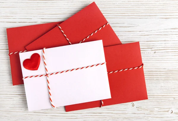 Envolvente de correo con corazón rojo y cinta en blanco. Tarjeta de San Valentín, Amor o Boda — Foto de Stock