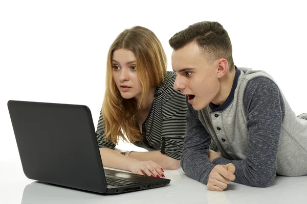 Chico y chica haciendo la tarea en el ordenador portátil —  Fotos de Stock