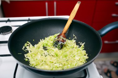 Wok tavada caramelizing soğan