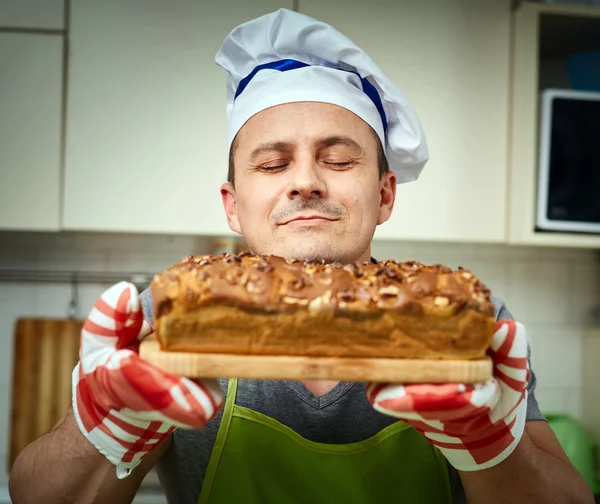 Koch hält Kuchen mit Walnüssen — Stockfoto