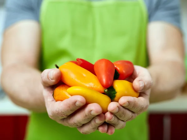 Cook drží papriky — Stock fotografie