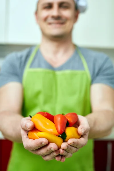 Cook drží papriky — Stock fotografie