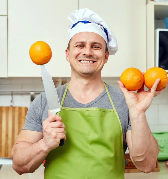 Cozinhar segurando laranjas frescas — Fotografia de Stock