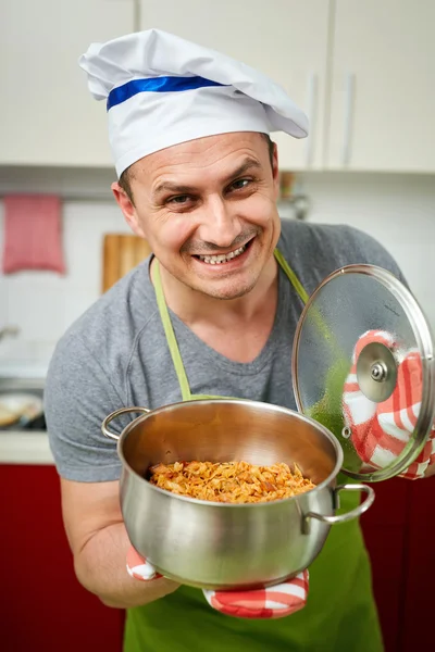 Hombre sosteniendo una olla con estofado de col — Foto de Stock