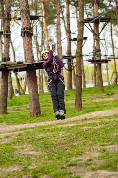 Vrouw op een hoge draad in een avonturenpark — Stockfoto