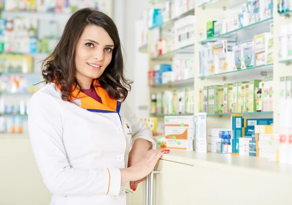 Mujer farmacéutica sobre fondo borroso de estantes —  Fotos de Stock