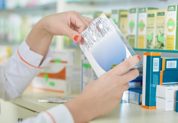 Pharmacist woman picking a medicine — Stock Photo, Image