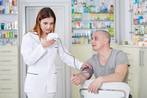 Lekarz sprawdzający ciśnienie krwi — Zdjęcie stockowe