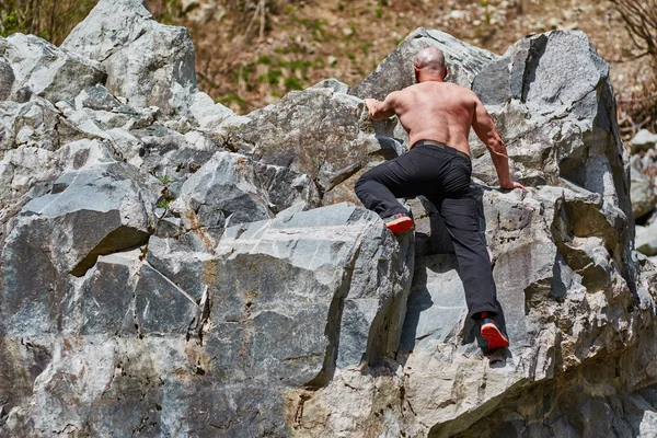 Mannen fri klättring på stora stenblock — Stockfoto