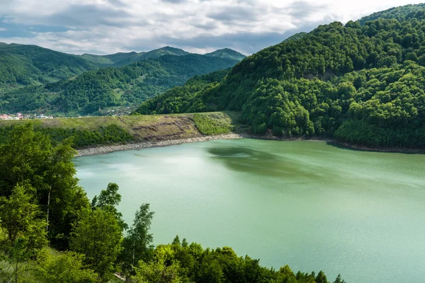 Lago entre montanhas cobertas de florestas — Fotografia de Stock