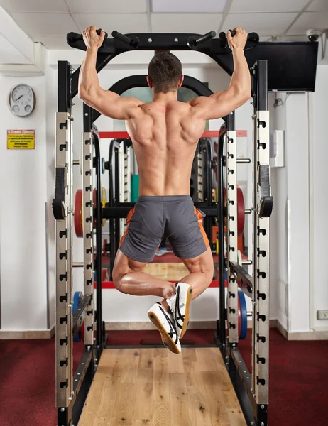 Homem fazendo pull-ups no ginásio — Fotografia de Stock