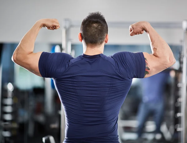 Uomo muscolare esaminando i suoi progressi — Foto Stock