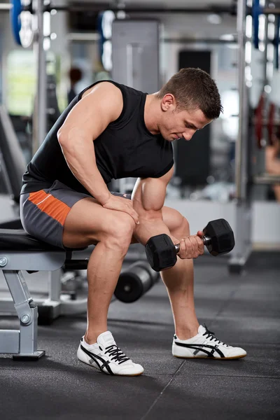 Hombre haciendo bíceps rizo sentado — Foto de Stock