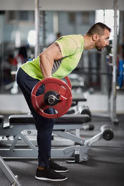 Αθλητική άνθρωπος κάνει barbell σειρά — Φωτογραφία Αρχείου