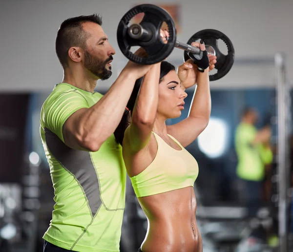 Trainer helping a young woman — Stock Photo, Image