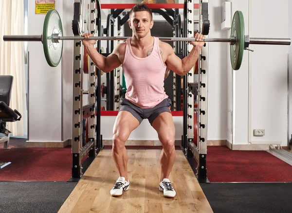 Hombre haciendo sentadillas con barra — Foto de Stock