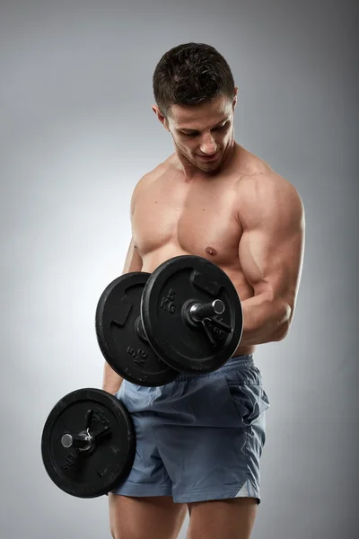 Athlete doing biceps curls with dumbbells — Stock Photo, Image