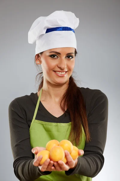 Mujer cocinera con albaricoques —  Fotos de Stock