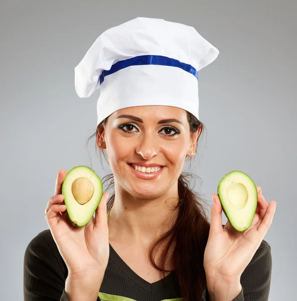 Koken houden een avocado en glimlachen — Stockfoto