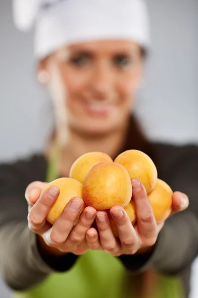 Mujer cocinera con albaricoques — Foto de Stock