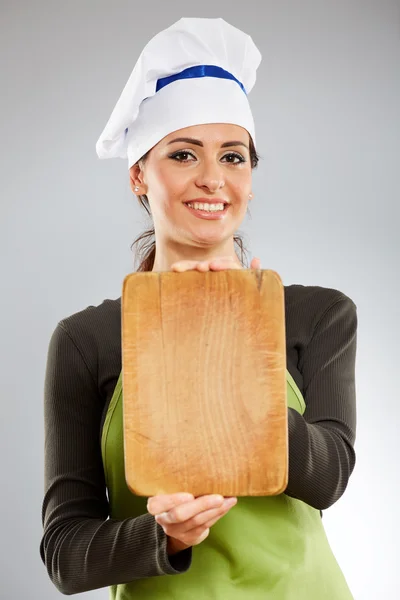 Köchin hält ein Holzbrett — Stockfoto