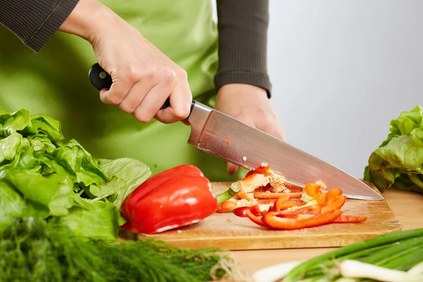 Mãos cortando legumes — Fotografia de Stock