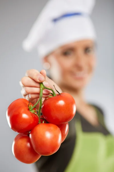 Koch hält einen Bund Tomaten in der Hand Stockbild