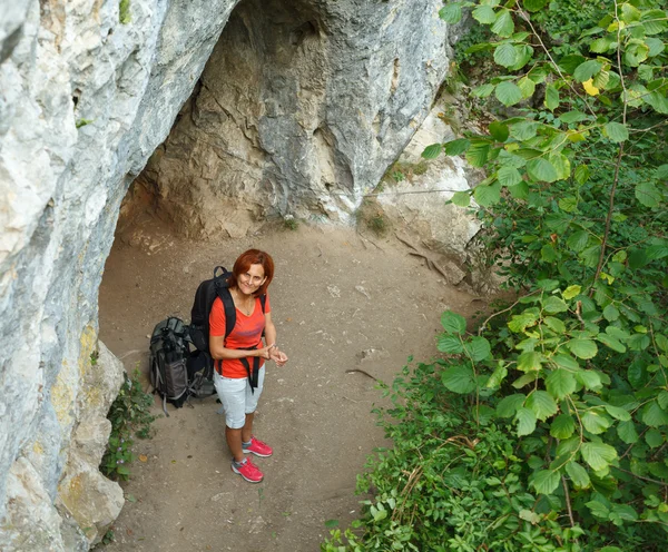 Wandelaar met rugzak in de buurt van de ingang van de grot — Stockfoto